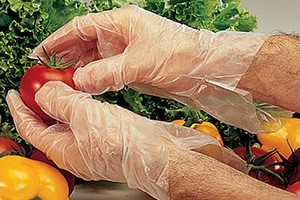 Image of a worker using wearing gloves whole holding food 
